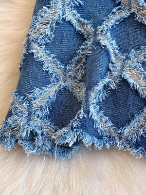 Distressed denim shorts with frayed diamond pattern and raw hem.