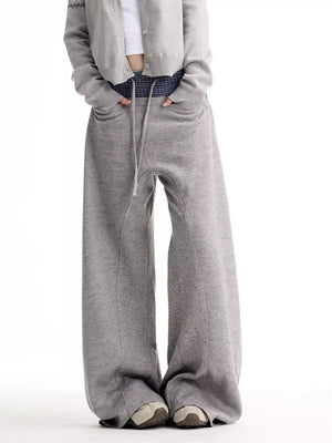 Grey wide-leg sweatpants with drawstring waist and pockets.
