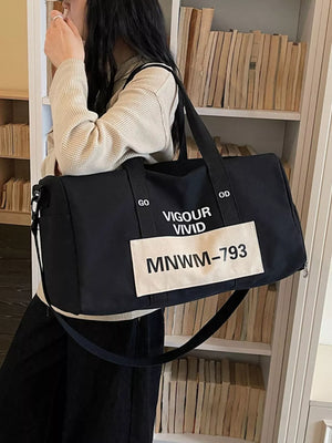 Black nylon travel bag with white text and a patch, featuring adjustable straps.
