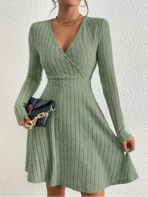 Sage ribbed wrap mini dress with V-neck and long sleeves, styled with a black chain bag.