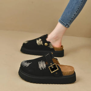 Black embroidered denim platform clogs with buckle detail and cork sole.