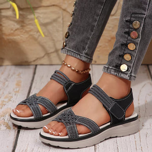 Black woven criss-cross platform sandals with adjustable straps and white stitching.