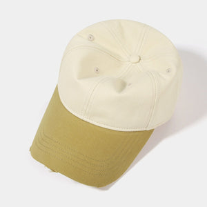 Distressed two-tone baseball cap in cream and olive green cotton with a curved brim.