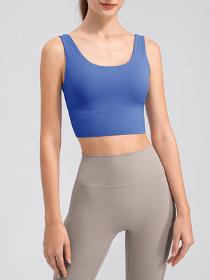 Blue scoop neck performance crop top with wide straps and a banded hem.