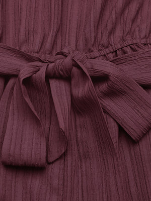 Chic one-shoulder romper in burgundy with a textured fabric and tie waist detail.