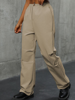 Khaki gathered-leg utility trousers with cuffed ankles and cargo pockets.
