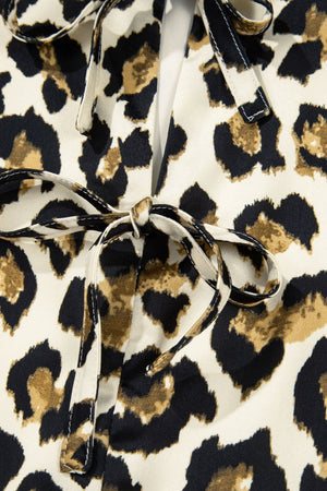 Leopard print blouse with tie-neck detail and peplum cut.