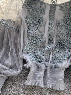Gray lace embroidered blouse with sheer sleeves and ruffled cuffs.
