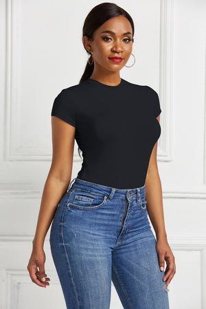 Black crew neck short sleeve bodysuit with a sculpted fit, paired with blue denim jeans.
