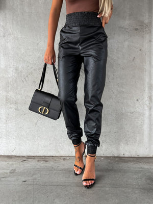 Black leatherette gathered waist joggers with cinched ankles.