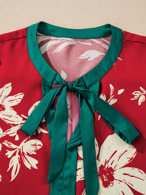 Red floral print blouse with green trim and a tied bow detail at the neckline.