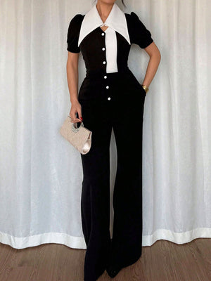 Black and white button-down wide leg jumpsuit with puff sleeves and a contrast collar.