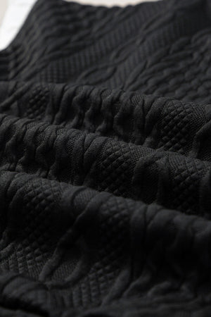 Black textured knit loungewear fabric with cable and diamond patterns.