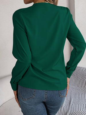Dark green long sleeve blouse with V-neckline and button cuffs.