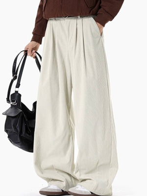 Cream pleated wide leg trousers with vertical ribbing detail.