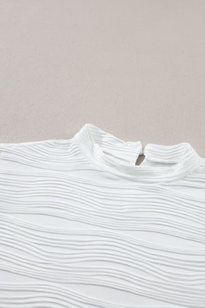 White textured mock neck top with cap sleeves and a wave pattern