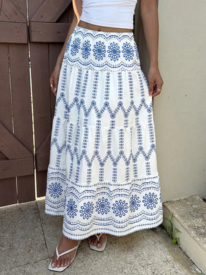 Bohemian maxi skirt with blue floral embroidery and tiered ruffles.