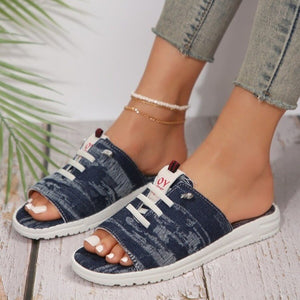 Distressed dark blue canvas open-toe platform sandals with white laces and platform sole.