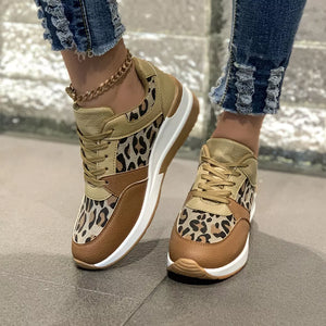 Leopard print lace-up sneakers with brown and tan color-block details and a white sole.