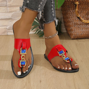 Red thong sandals with rhinestone chain detail and blue gems.