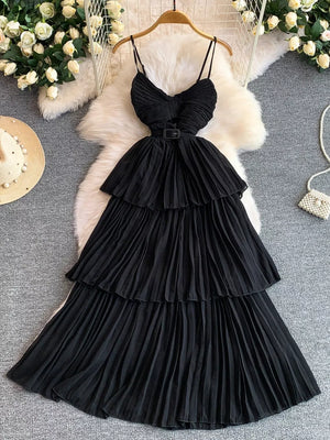 Black belted midi dress with spaghetti straps, tiered pleated skirt and buckle detail.