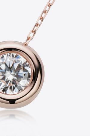 Rose gold bezel-set moissanite solitaire necklace with a delicate chain.