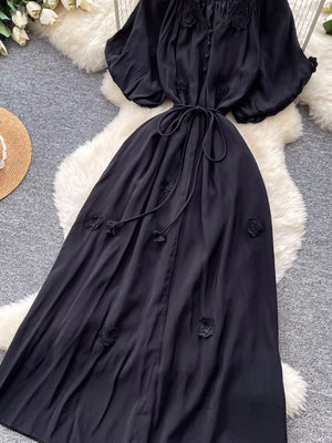 Black floral maxi dress with puff sleeves and tie waist.