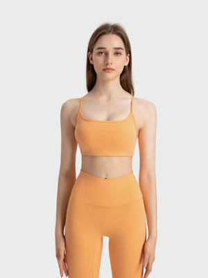 Strappy back active crop top in peach with a scoop neckline.