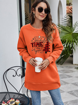 Orange tunic sweatshirt with holiday graphic and plaid Christmas tree detail.