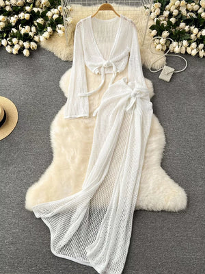 White knit tied crop top with long sleeves and matching high slit maxi skirt.