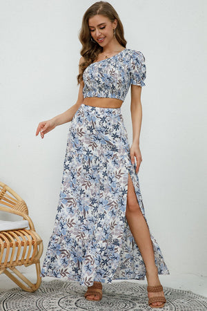 Floral one-shoulder crop top and high-slit maxi skirt set with blue and white floral print.