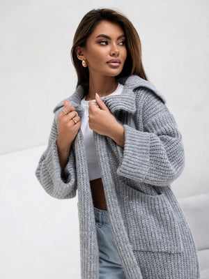 Oversized gray knit cardigan with lapel neckline and pockets, styled casually.