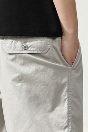Light gray chino shorts with button-flap back pocket and side pocket detail.