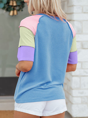 Color block patchwork henley t-shirt with blue stripes and pastel sleeves.