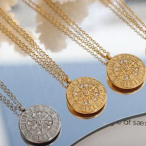 Zodiac compass pendant necklaces in gold and silver with crystal accents.
