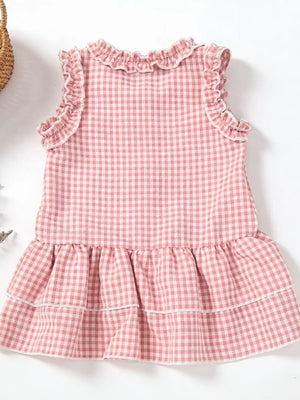 Blush pink gingham baby dress with ruffled neckline and tiered skirt