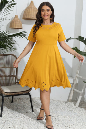 Mustard yellow midi dress with short sleeves and laser cutouts on the neckline and hem.