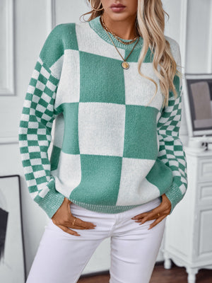 Checkerboard knit sweater in turquoise and white with a crew neck and long sleeves.