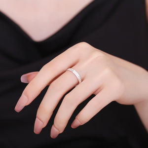 Textured sterling silver ring with a subtle pattern, worn on a woman's finger.
