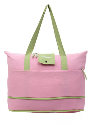 Pink and green two-tone nylon travel bag with front pocket and green straps.