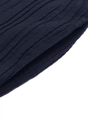 Navy blue textured fabric detail of a ruffled peplum tube top and wide-leg pants set.