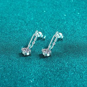 Silver link moissanite drop earrings with dazzling stones on a textured teal background.
