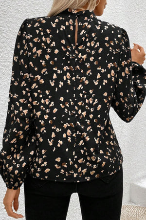Black high-neck blouse with abstract print and long puff sleeves.