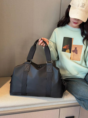 Sleek black Oxford cloth travel duffel bag with double handles and a crossbody strap.