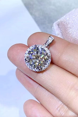 Platinum halo necklace with a round moissanite center stone and diamond accents.