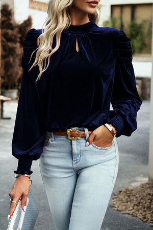 Navy velvet keyhole blouse with puff sleeves and smocked cuffs.