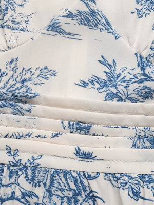 Toile print midi dress with blue scenic pattern, V-neck, and ruched waist detail.