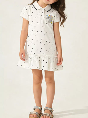 White polka dot cotton dress with unicorn patch and ruffled hem.