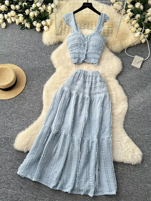 Light blue textured two-piece set with ruffled details, buttoned crop top and tiered maxi skirt.