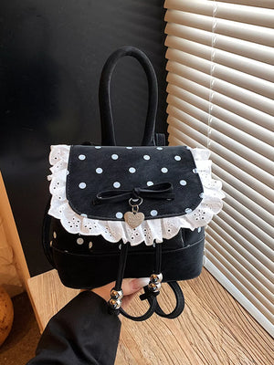 Black polka dot mini backpack with white lace trim and bow detail.